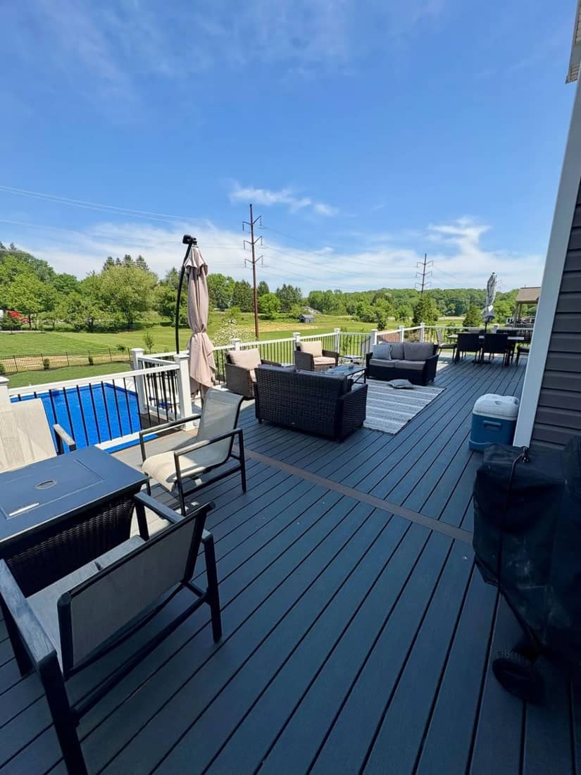 Composite deck with outdoor seating overlooking a pool and open fields
