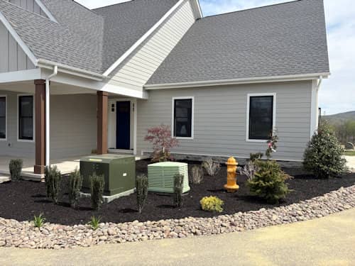 Finished front landscape with mulch beds, river rock, and plantings in Boiling Springs, PA